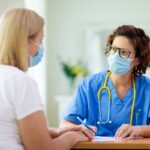 Doctor examining sick patient. Ill woman in clinic