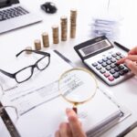 Businesswoman Checking Invoice With Magnifying Glass