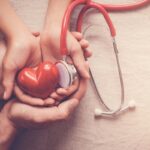 child and adult holding red heart with stethoscope, heart health, health insurance concept, world heart day, world health day, world hypertension day, health insurance child and adult holding red heart with stethoscope, heart health, health insurance concept, world heart day, world health day, world hypertension day, health insurance
