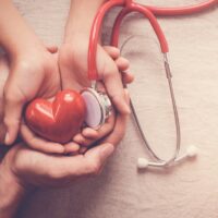 child and adult holding red heart with stethoscope, heart health,  health insurance concept, world heart day, world health day, world hypertension day, health insurance