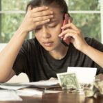 A stressed woman with no money looking at her credit card bills and monthly payments. Financial crisis debt.