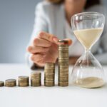 Businesswoman With Hourglass And Stack Of Coins Businesswoman With Hourglass And Stack Of Coins