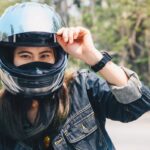 Young Asian woman wearing a motorcycle helmet before riding. Hel Young Asian woman wearing a motorcycle helmet before riding. Hel