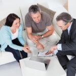 Happy Couple And Mature Consultant Discussing Together Happy Couple And Mature Consultant Discussing Together