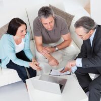 Happy Couple And Mature Consultant Discussing Together Happy Couple And Mature Consultant Discussing Together
